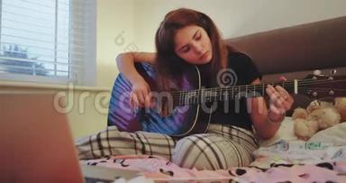 在放学后的房间里玩吉他的有魅力的小女孩在休息时享受时光